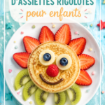 Assiette colorée et amusante pour enfants, avec des légumes et des fruits disposés de manière ludique.