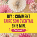 Un éventail DIY coloré fabriqué à la main, posé sur une table en bois.